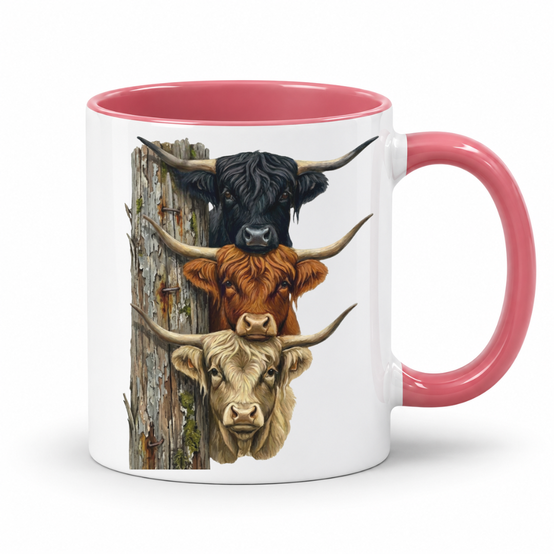 A white ceramic mug with a pink interior and handle, featuring a graphic print of three Highland cattle heads stacked vertically next to a weathered wooden post.  From Coffee and Moo NZ