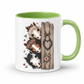 A white ceramic mug with a light green interior and handle, featuring a printed illustration of three horse heads peeking from behind a rustic wooden fence with a hanging heart. From Coffee and Moo
